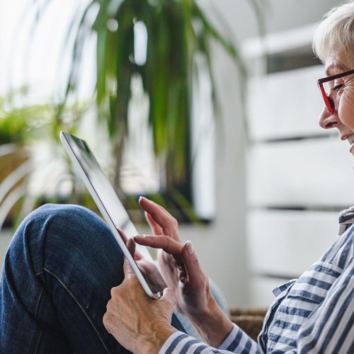 a person sitting on a chair and looking at a cell phone