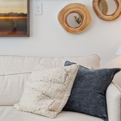 couch with pillow and end table with a lamp